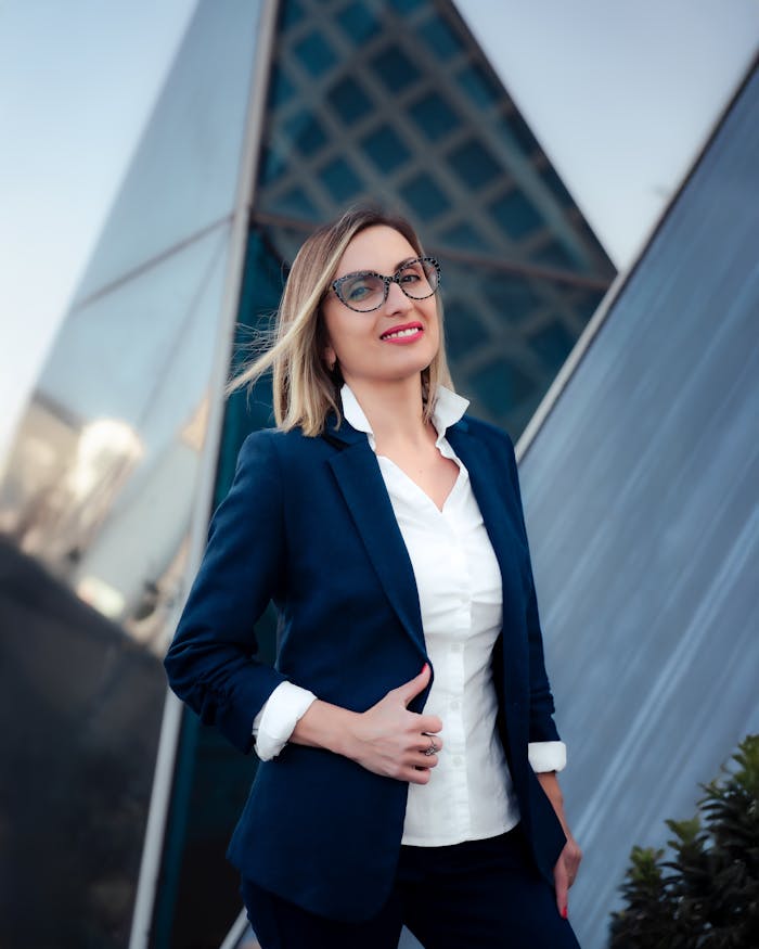 Professional woman in blue suit with modern architecture backdrop.
